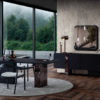 Contemporary dining area with a dark table and chairs on a round gray rug marble pedestal base and floor to ceiling windows overlooking greenery
