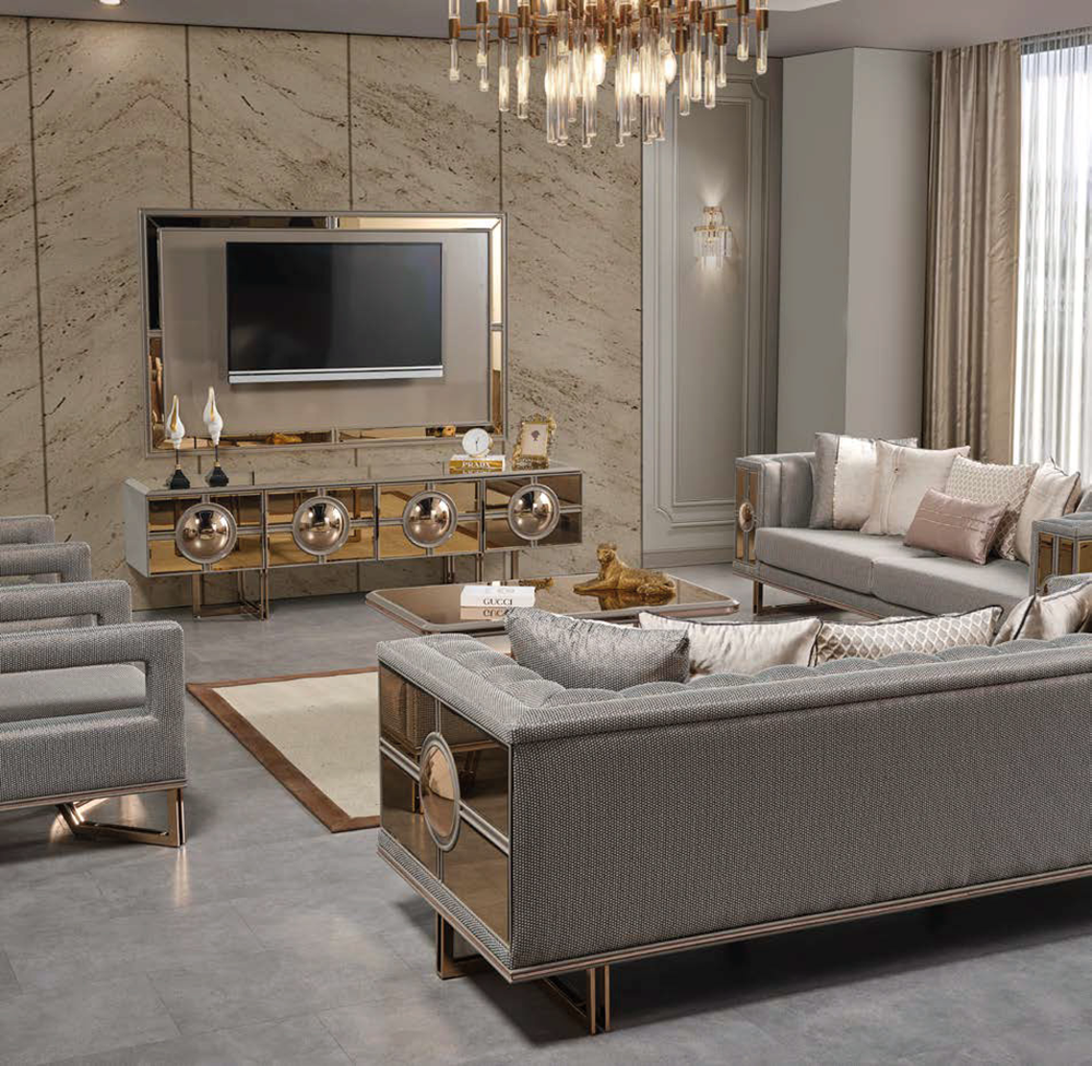 Luxurious living room with gray upholstered sofas gold framed mirrors and a wall mounted TV