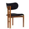 Side view of a wooden dining chair with black padded seat and backrest