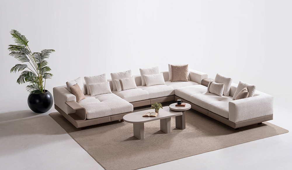 Roma Corner Set 4 Armonna L shaped beige sectional sofa with multiple cushions on a light beige rug two oval coffee tables and a potted plant in a black pot in a bright minimalist room