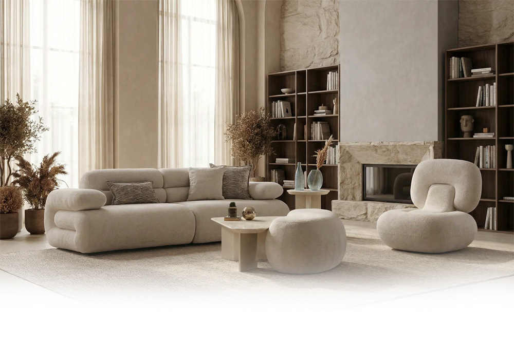Neutral-toned modern living room with a beige sectional sofa, rounded lounge chair, and matching ottoman by a stone fireplace