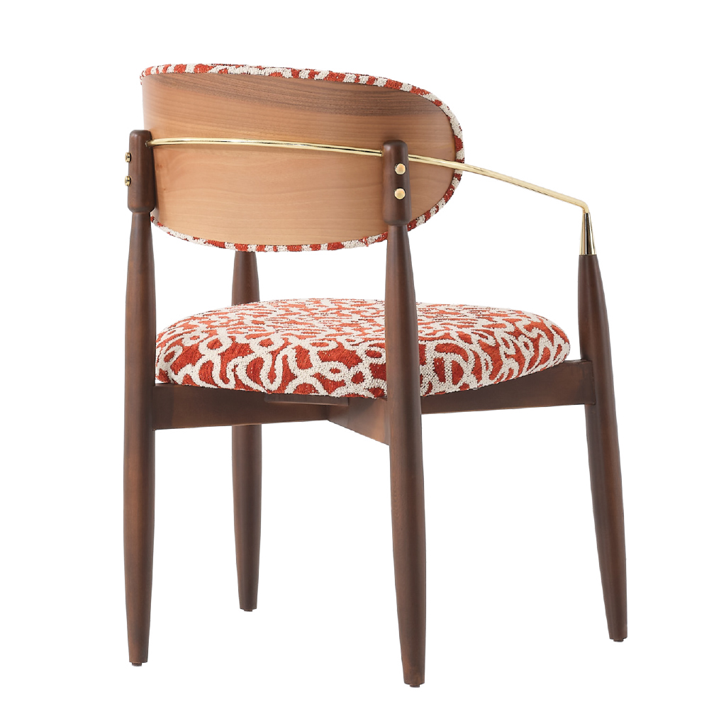 Mid century wooden chair with a curved wooden back red patterned upholstery and tapered legs gold rod arm supports add a vintage touch