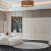 Luxurious modern bedroom showroom with a beige upholstered bed circular rug and white wardrobe cabinets