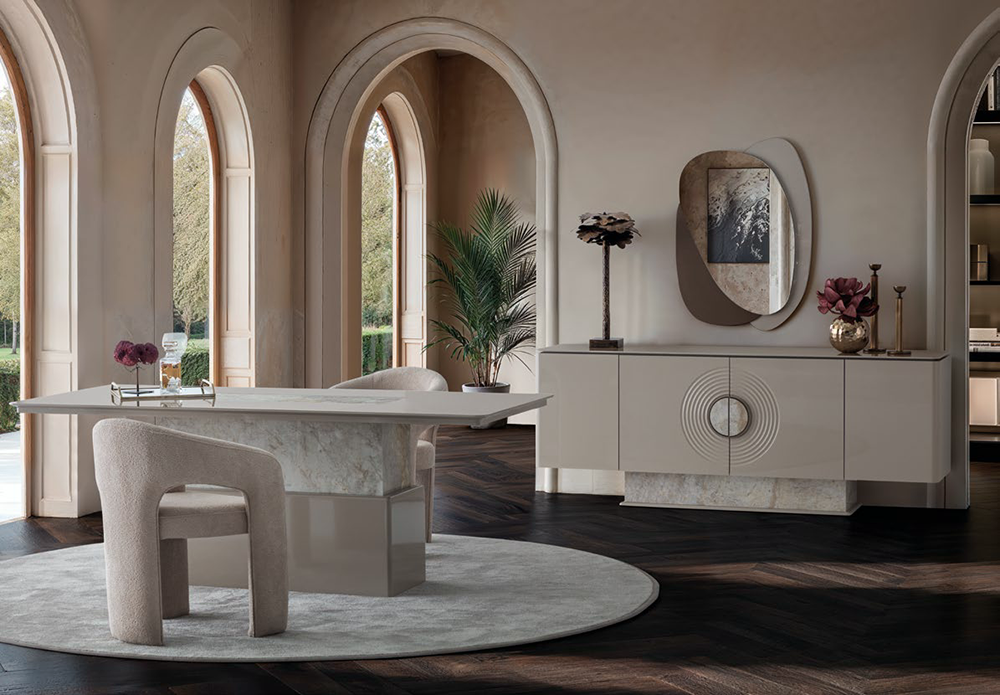 Luxurious neutral dining room with a long white table, soft upholstered chairs, and a beige sideboard under arched windows.