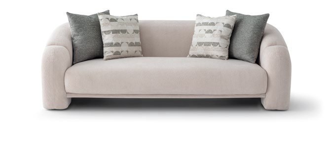 Beige sofa with four cushions: two dark gray and two beige patterned pillows.