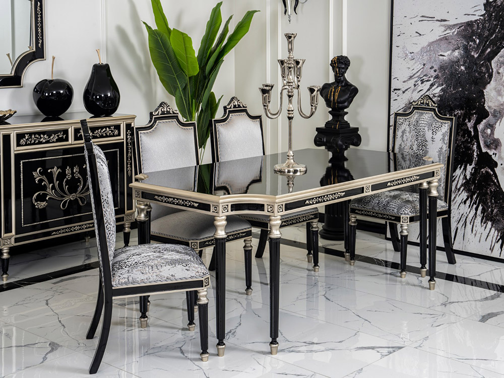 Luxurious black and silver dining table set with six upholstered chairs on a marble floor, centerpiece candelabra.