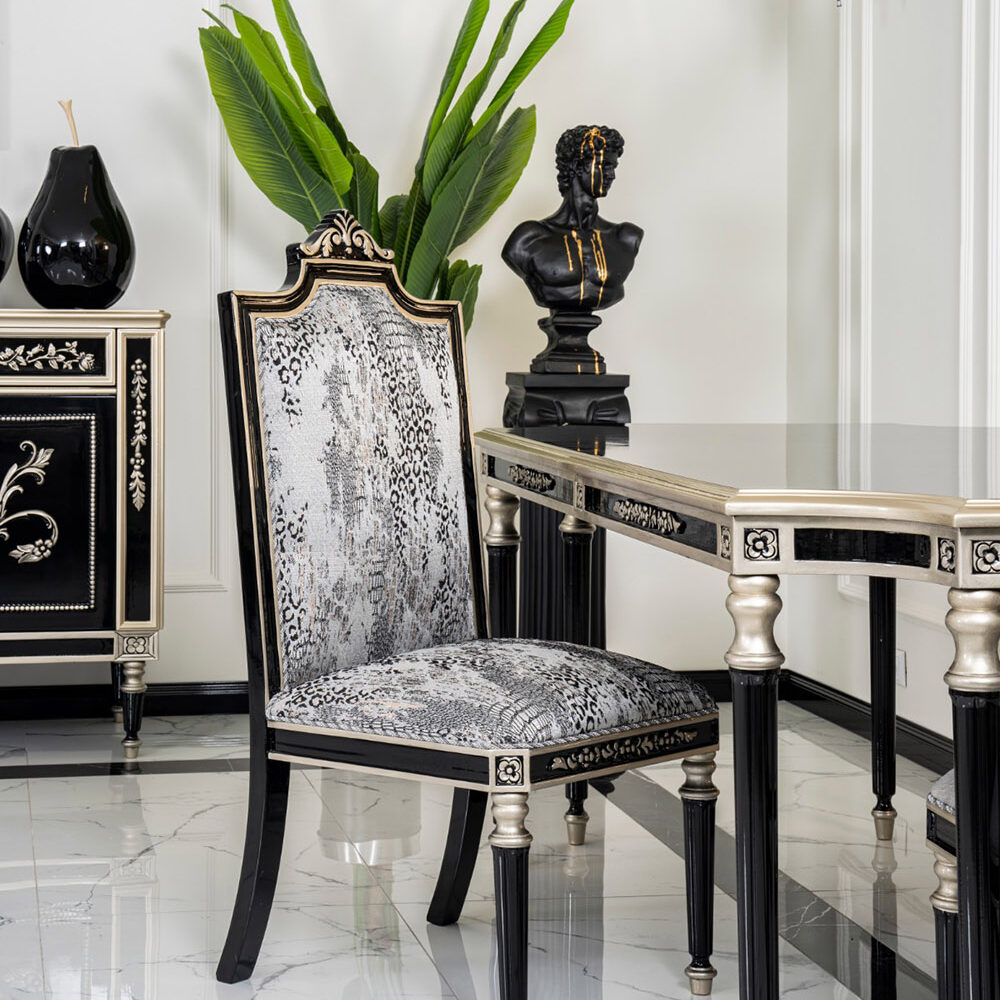 Luxurious black and gold dining set with a snakeskin‑pattern chair, marble floor, and a decorative bust beside a green plant.