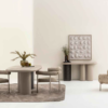 Minimal beige dining nook with a round table and four cushioned chairs on a soft rug against pale walls