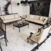 Luxurious cream and black living room with tufted sofas matching chairs and a glass coffee table on a white marble floor