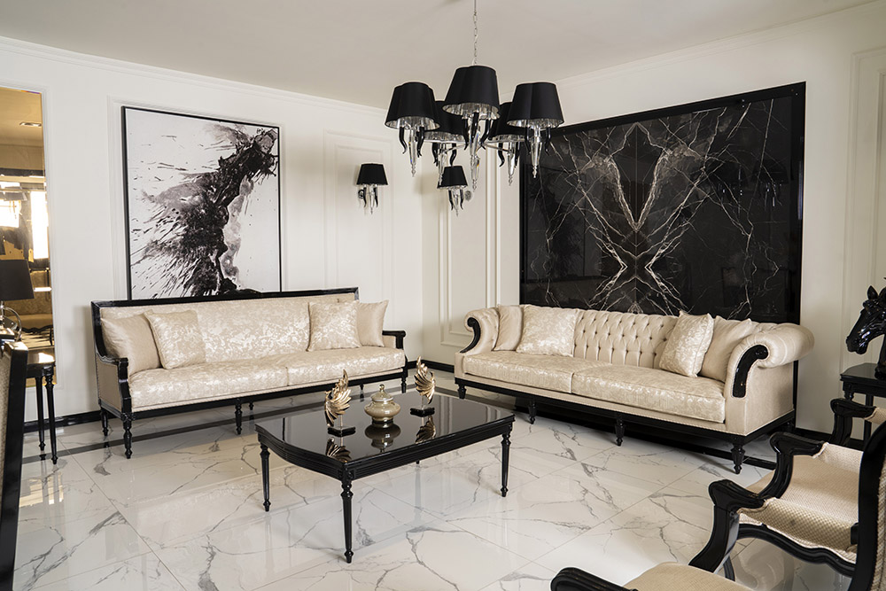 Luxurious living room with cream tufted sofas, black carved wood detailing, and marble floors.