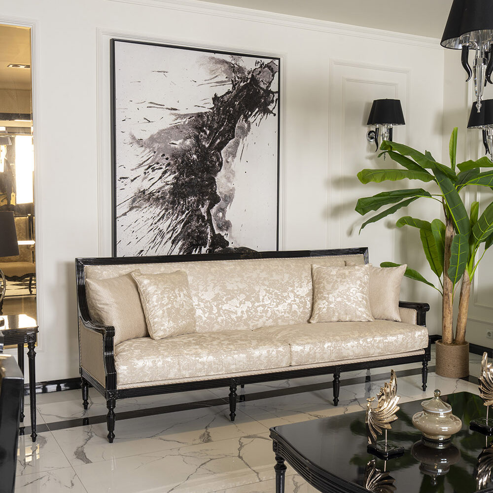 Elegant living room with a beige tufted sofa, black frame, and abstract black-and-white artwork on a white paneled wall