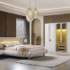 Modern bedroom with a beige upholstered bed white nightstand rug and a large white wardrobe with a central glass display cabinet