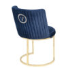 Blue velvet upholstered chair with vertical channeling and a gold circular pedestal base