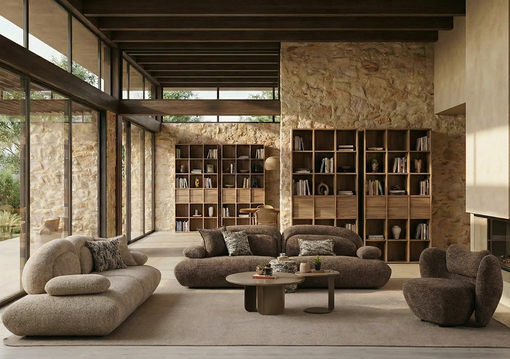 Bright open living room with floor-to-ceiling glass walls, a stone accent wall, and brown modular couches around a coffee table.