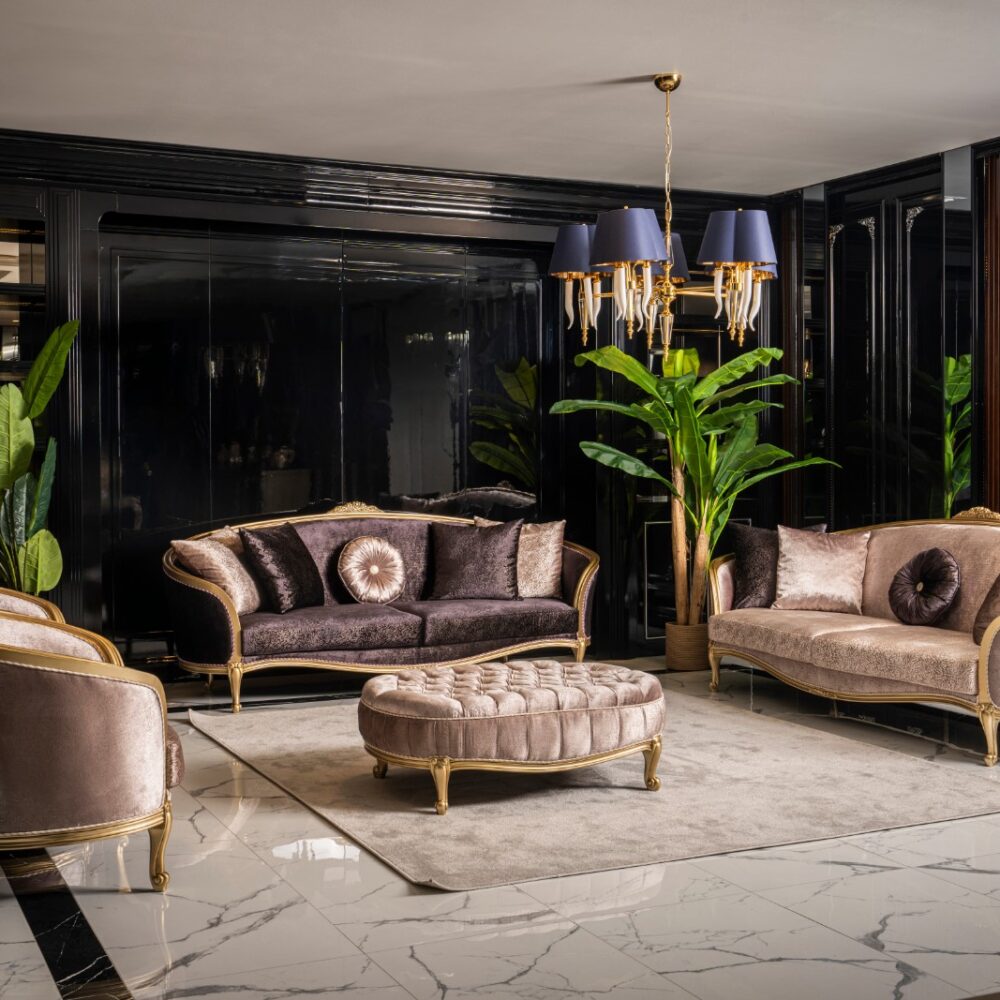 Luxurious black-and-gold living room with velvet sofas, a tufted ottoman, and lush green plants under a blue-shaded chandelier