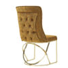 Gold velvet tufted chair with a circular brass metal base shown from the side