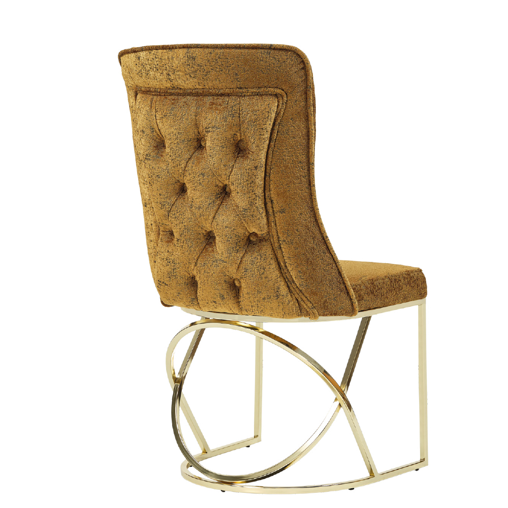 Gold velvet tufted chair with a circular brass metal base shown from the side