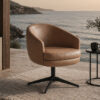 Tan leather swivel chair on a patio by the sea with a round black base and nearby side table