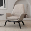 Cream boucle armchair with black angled legs in a neutral living room on a textured rug