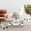 milanooffice Armonna Three contemporary swivel office chairs in peach cream and olive green displayed on white platforms in a bright showroom