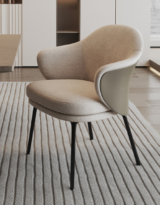 Beige upholstered armchair with a curved back and black legs on a striped rug in a modern living room.