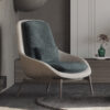 Modern upholstered lounge chair with cream shell and teal cushions in a living room beside a wooden sideboard and green vase