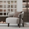 Beige upholstered armchair with wooden legs beside a linear fireplace in a modern living room