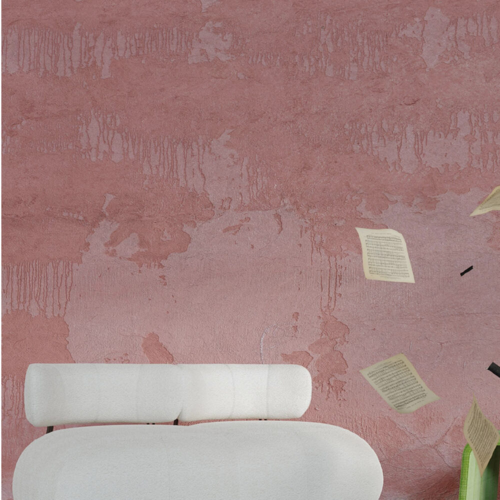 Contemporary white sectional sofa in a pink-washed room with scattered papers and bright lime and yellow cushions on the floor.