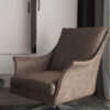 Brown leather upholstered swivel armchair with wide arms in a living room placed on a patterned rug in front of white built in cabinets