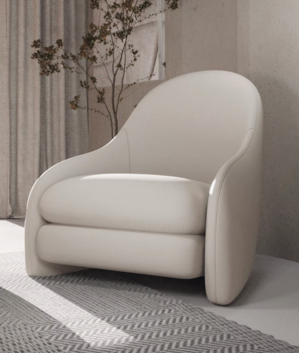 White modern upholstered armchair with rounded arms in a bright living room beside a tall plant and striped curtains.