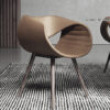 stil Armonna Brown molded lounge chair with wood legs on a striped rug in a modern interior space