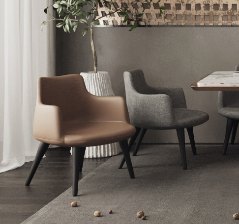 Modern seating area with tan and gray armchairs around a wooden table, a potted plant nearby, and nuts scattered on the rug.